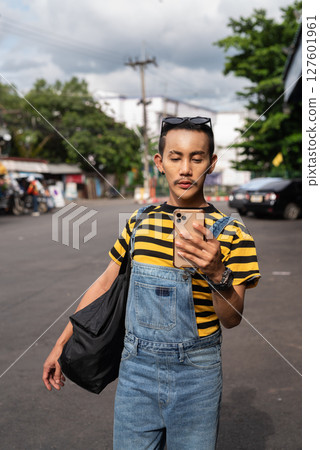 Portrait of nonbinary genderfluid young Asian gay tourist man in bus terminal walking 127601961