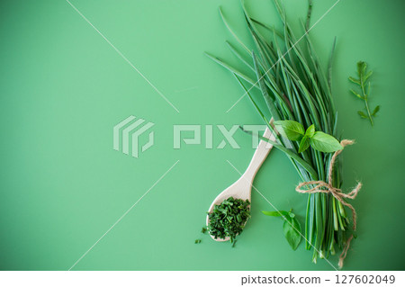 Slices of fresh and dried onions on green surface 127602049
