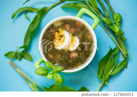 Traditional Ukrainian sorrel borscht with egg on blue background 127602051