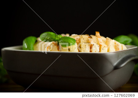 Sliced potatoes in a baking dish 127602069