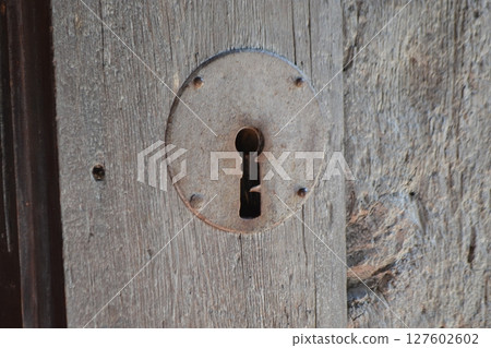 Rustic keyhole on weathered wooden door in Brihuega spain for architectural design and historic decor. Iglesia de San Felipe. Church Saint Felipe in Brihuega, Guadalajara, Spain 127602602