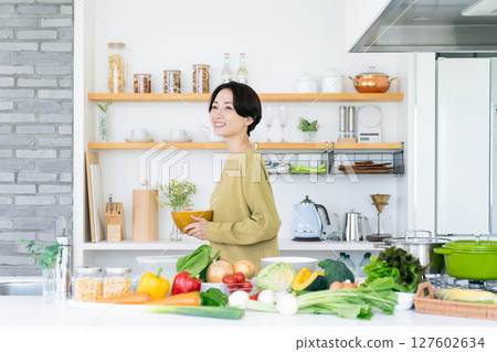 Middle-aged woman in the kitchen 127602634