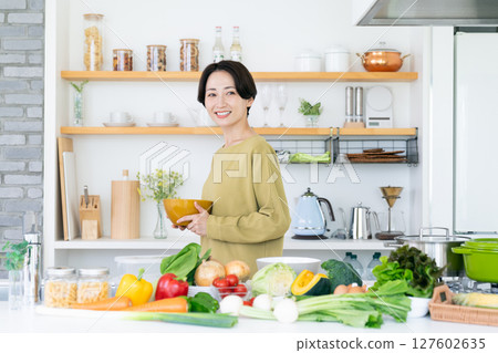 Middle-aged woman in the kitchen 127602635