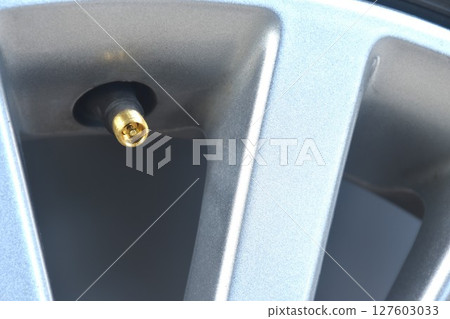 brass screw tire value on magnesium alloy wheel background and texture brass screw tire value on magnesium alloy wheel background and texture 127603033