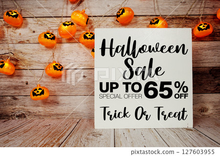 Halloween Sale 65% off text with LED pumpkin decoration on wooden background 127603955