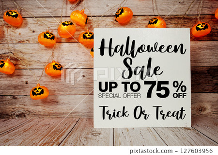 Halloween Sale 75% off text with LED pumpkin decoration on wooden background 127603956