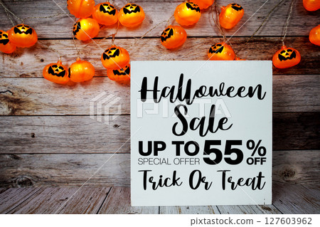 Halloween Sale 55% off text with LED pumpkin decoration on wooden background 127603962