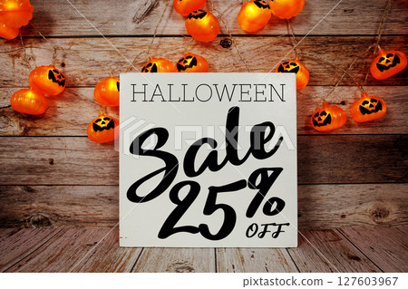 Halloween Sale 25% off text with LED pumpkin decoration on wooden background 127603967