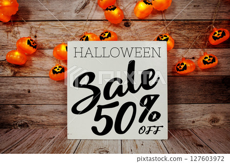 Halloween Sale 50% off text with LED pumpkin decoration on wooden background 127603972