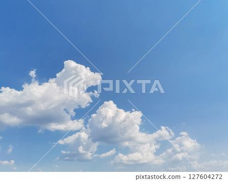 Bright blue sky with fluffy white clouds creating a serene and peaceful atmosphere Bright blue sky with fluffy white clouds creating a serene and peaceful atmosphere 127604272