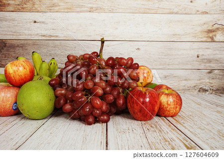 Various of fruits with Red grape, red apple and green orange on wooden background Various of fruits with Red grape, red apple and green orange on wooden background 127604609