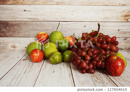 Various of fruits with Red grape, red apple and green orange on wooden background Various of fruits with Red grape, red apple and green orange on wooden background 127604610