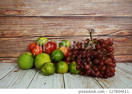 Various of fruits with Red grape, red apple and green orange on wooden background Various of fruits with Red grape, red apple and green orange on wooden background 127604611