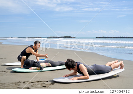 Instructor teaching the basic movements of surfing Surfing class image Instructor teaching the basic movements of surfing Surfing class image 127604712