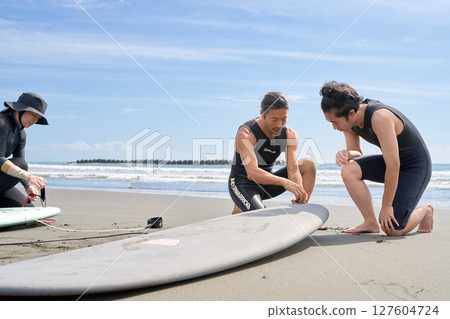 An instructor carefully teaches you how to prepare before surfing 127604724