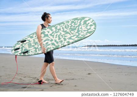 年輕人帶著衝浪板沿著海灘散步 127604749