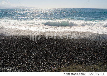 A Serene Coastal Scene Featuring a Pebbled Shoreline Overlooked by Gentle Waves Nearby A Serene Coastal Scene Featuring a Pebbled Shoreline Overlooked by Gentle Waves Nearby 127605111