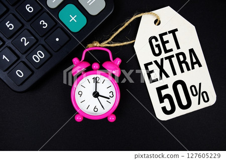 Get Extra 50% text on price tag with alarm clock and calculator on black background Get Extra 50% text on price tag with alarm clock and calculator on black background 127605229
