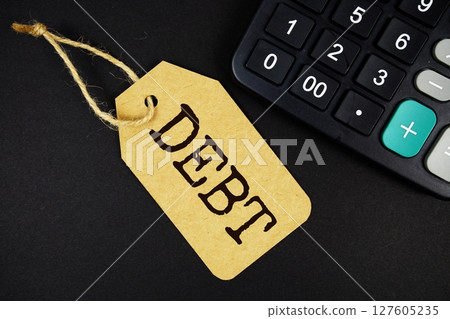 Debt text on price tag with calculator on black background Debt text on price tag with calculator on black background 127605235