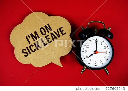 I'm on Sick Leave text on speech bubble with alarm clock on red background 127605243