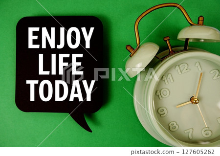 Enjoy Life Today text on speech bubble with alarm clock on green background 127605262