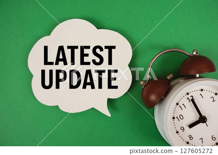 Latest Update text on speech bubble with alarm clock on green background Latest Update text on speech bubble with alarm clock on green background 127605272