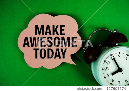 Make Awesome Today text on speech bubble with alarm clock on green background Make Awesome Today text on speech bubble with alarm clock on green background 127605274