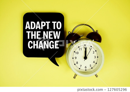 Adapt To The New Change text on speech bubble with alarm clock on yellow background 127605296