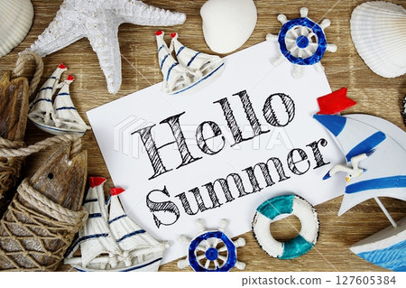 Hello Summer text on paper card with colorful pinwheel top view on wooden background 127605384