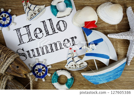 Hello Summer text on paper card with marine items decorative top view on wooden background 127605386