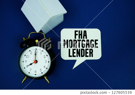 FHA Mortgage Lender text with alarm clock and house model top view on blue background FHA Mortgage Lender text with alarm clock and house model top view on blue background 127605539