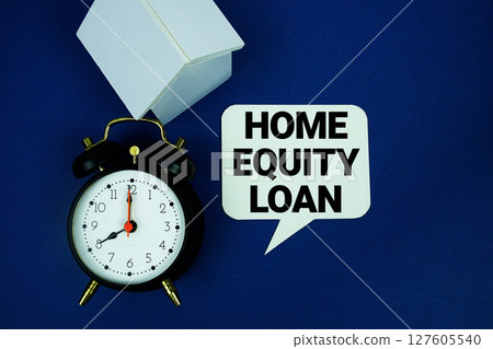 Home Equity Loan text with alarm clock and house model top view on blue background Home Equity Loan text with alarm clock and house model top view on blue background 127605540
