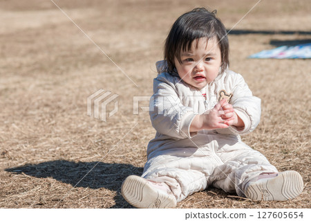 [相模原市立麻溝公園，一位一歲兒童坐在草地上玩耍] 127605654