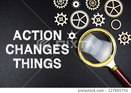 Action Changes Things text message with magnifying glass on black background Action Changes Things text message with magnifying glass on black background 127605750
