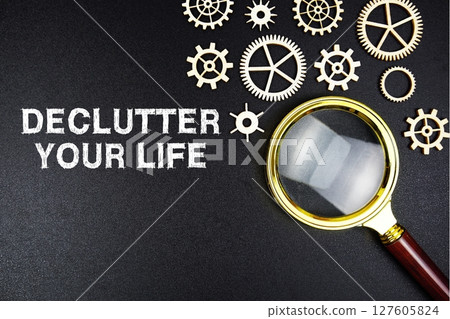 Declutter Your Life text message with magnifying glass on black background Declutter Your Life text message with magnifying glass on black background 127605824