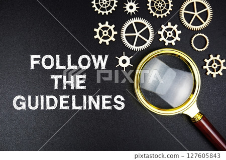 Follow the Guidelines text message with magnifying glass on black background 127605843