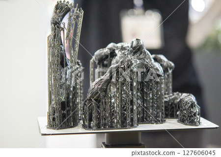 An object printed on a 3D printer from hardened rubber close-up. Model black color created on a 3D printer from hardened rubber under influence of ultraviolet light. SLA 3D printing. Stereolithography 127606045