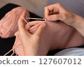 A woman crochets at home 127607012