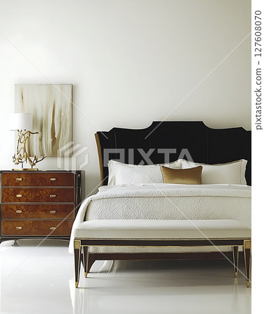 A bedroom with a black headboard and a white bedspread A bedroom with a black headboard and a white bedspread 127608070