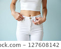 A woman is wearing white pants and a white top 127608142