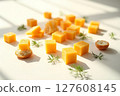 A plate of cheese cubes and crackers with a few pieces of cheese on the plate 127608145