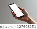 A hand holding a black iPhone with a white screen 127608151