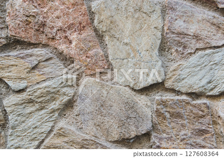 Beautiful beige structural stone wall of the ancient building consists of small bricks. Beautiful beige structural stone wall of the ancient building consists of small bricks. 127608364