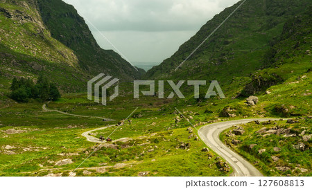 Picturesque mountain pass in Ireland. Road snakes between dramatic peaks; nature's artistry. Picturesque mountain pass in Ireland. Road snakes between dramatic peaks; nature's artistry. 127608813