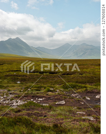 A picture of a mountain landscape is shown. It is in County Kerry, Ireland. The mountain landscape is in a green field. There are fluffy clouds in the blue sky. A picture of a mountain landscape is shown. It is in County Kerry, Ireland. The mountain landscape is in a green field. There are fluffy clouds in the blue sky. 127608814
