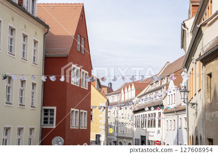 A Charming European Street Featuring Vibrant Buildings and Festive Seasonal Decorations A Charming European Street Featuring Vibrant Buildings and Festive Seasonal Decorations 127608954