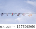 A Stunning Display of Colorful Paper Birds Elegantly Hanging Against a Bright Blue Sky 127608960