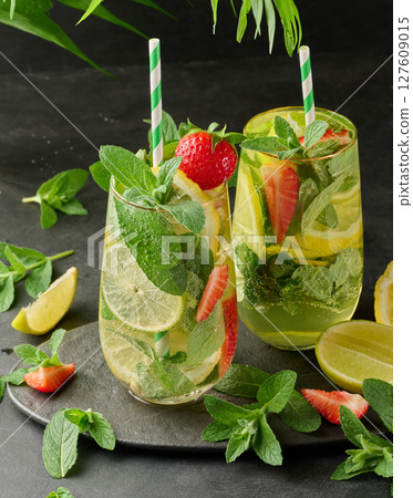 A refreshing drink in a glass with lemon slices, strawberries, fresh mint leaves, and sparkling water A refreshing drink in a glass with lemon slices, strawberries, fresh mint leaves, and sparkling water 127609015