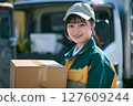 A female delivery driver delivers with a smile A female delivery driver delivers with a smile 127609244