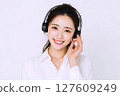 Smiling woman listening to music through headphones Smiling woman listening to music through headphones 127609249
